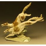 A Hutschenreuther model of two Borzoi dogs leaping over a rocky outcrop, designed by Karl Tutter,