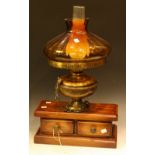 A contemporary table lamp in the style of an oil lamp, amber glass shade, fitted to a mahogany base,