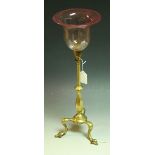 A brass table lamp, attributed to WS Benson, brass column, tripod feet, cranberry glass shade, 44.