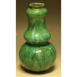 A Della Robbia slender double gourd vase, slip glazed in green,