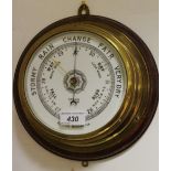 An early 20th century brass and oak aneroid barometer, porcelain dial marked Gamage,