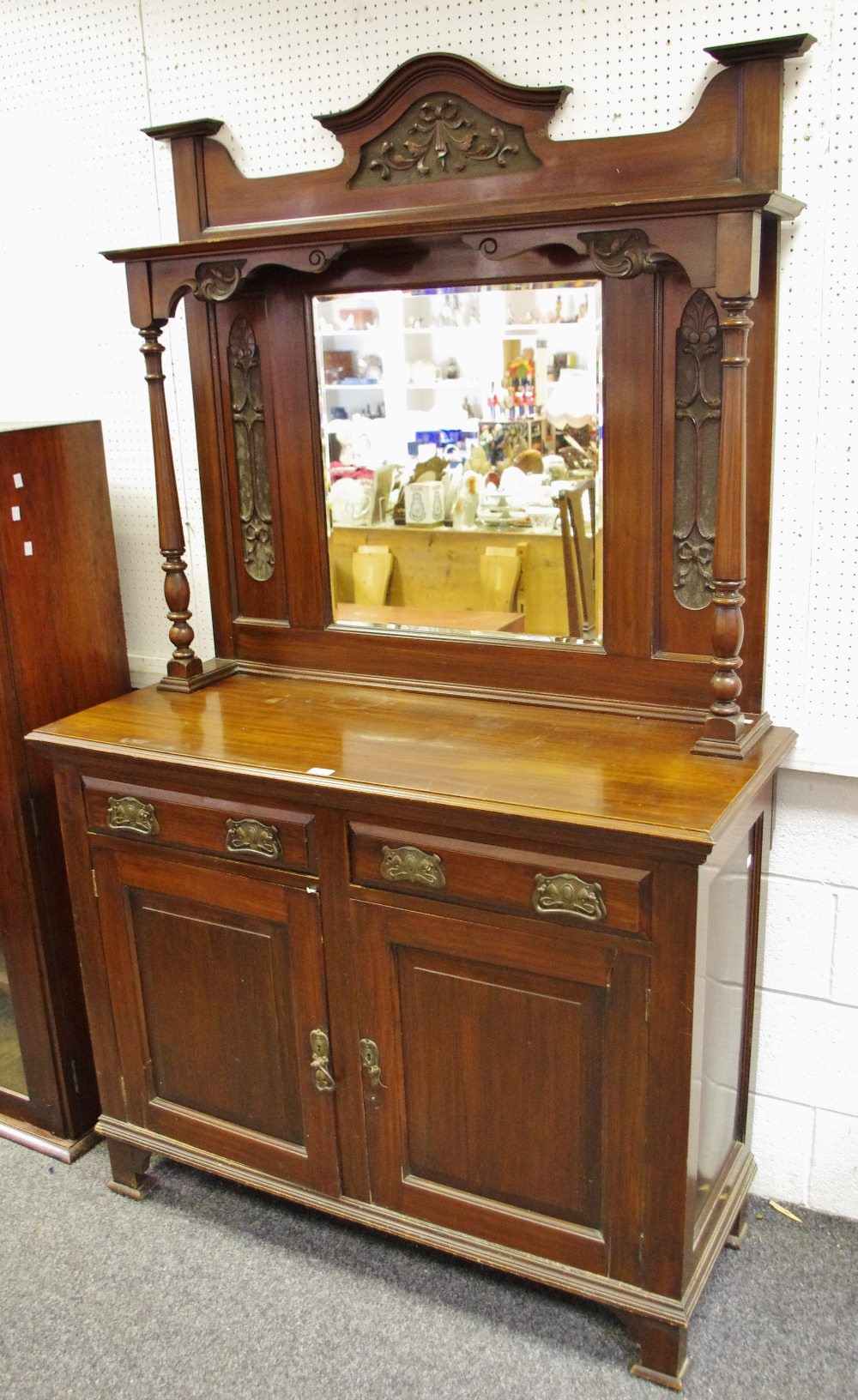 A late Victorian mahogany mirror backed sideboard, arched top carved with ribbon tied swags,