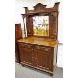 A late Victorian mahogany mirror backed sideboard, arched top carved with ribbon tied swags,