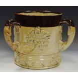 A late 19th century salt glazed stoneware three handled loving cup, embossed with jolly topers,