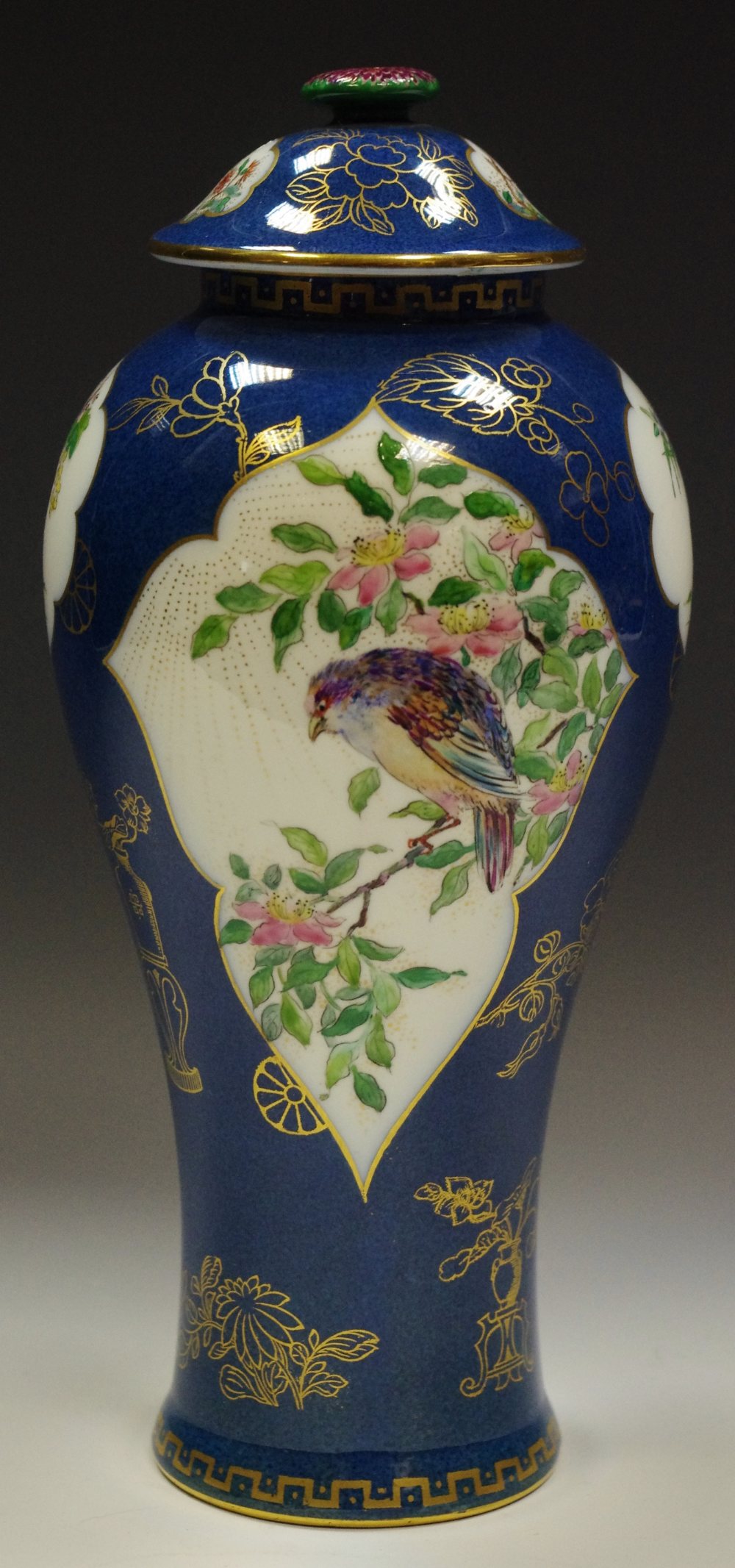 A Wedgwood slender inverted baluster vase and cover decorated with birds amongst flowering stems,