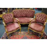 A satinwood salon suite comprising two seat sofa and two armchairs, button upholstered,