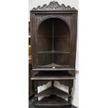 An oak corner cabinet on stand, shaped and carved pediment, two shelves,