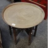 A North African folding table, brass top,