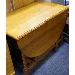 An early 20th century golden oak dropleaf gateleg dining table