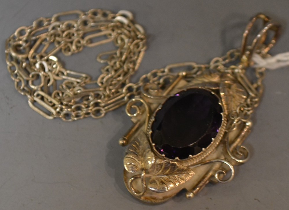 An ornate silver amethyst pendant,