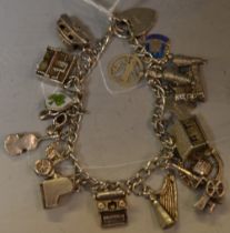 A silver charm bracelet and padlock with 17 charms,