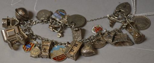 A silver charm bracelet and padlock with 23 charms,