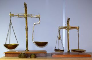 A set of 20th century balance scales, brass on wooden base, approx 60cm high; another similar,