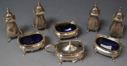 A set three George V silver open salts, raised on four pad feet, blue glass liners,