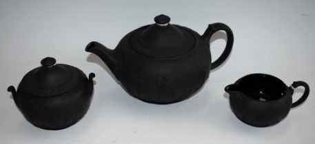 A Wedgwood three piece black basalt teapot, milk jug and sugar bowl,