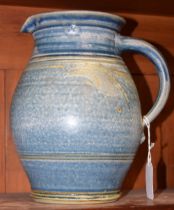 A stoneware ribbed ovoid jug, attributed to Richard Hamer, slip glazed in mottled blue, 21.