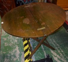 An early 20th century stained pine collapsible coaching table, 90cm diam, label to underside,