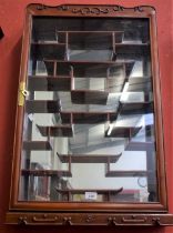 A Chinese style hardwood display cabinet, mirror backed, various display shelves,