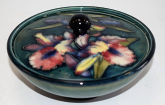 A Moorcroft pottery Orchid pattern tube lined powder bowl and cover, deep green blue ground,