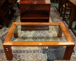 A contemporary glass topped coffee table;