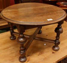 An early 20th century oak low occasional table, circular moulded top, bold turned supports,