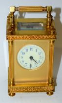 A French gilt metal carriage clock, the white dial with blue Arabic numerals,