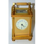 A French gilt metal carriage clock, the white dial with blue Arabic numerals,