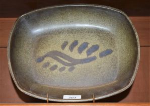 A Sam Haile stoneware rounded rectangular dish, resting on four peg feet,