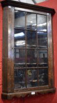 An early 20th century oak corner display cabinet,