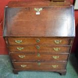 A George III oak bureau, fall front enclosing small drawers above four long graduated drawers,