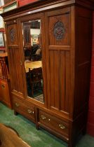 An early 20th century wardrobe, outswept cornice above a single mirrored door,