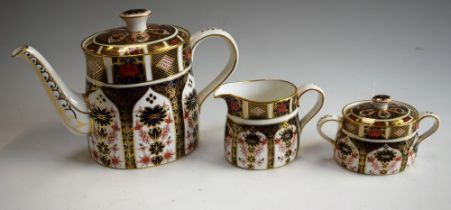 A Royal Crown Derby 1128 pattern tea pot; a similar sucrier and milk jug,