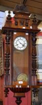 A mahogany cased Vienna type wall clock, architectural pediment crested by an eagle,