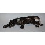 A reproduction cast metal figure, as a lioness stalking,