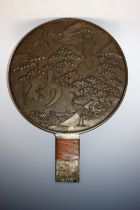 A Japanese bronze 'Meiji' period mirror, decorated with cranes amongst blossoming prunus,