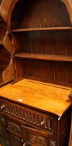 A 17th century style oak dresser, arched top with two plate racks,