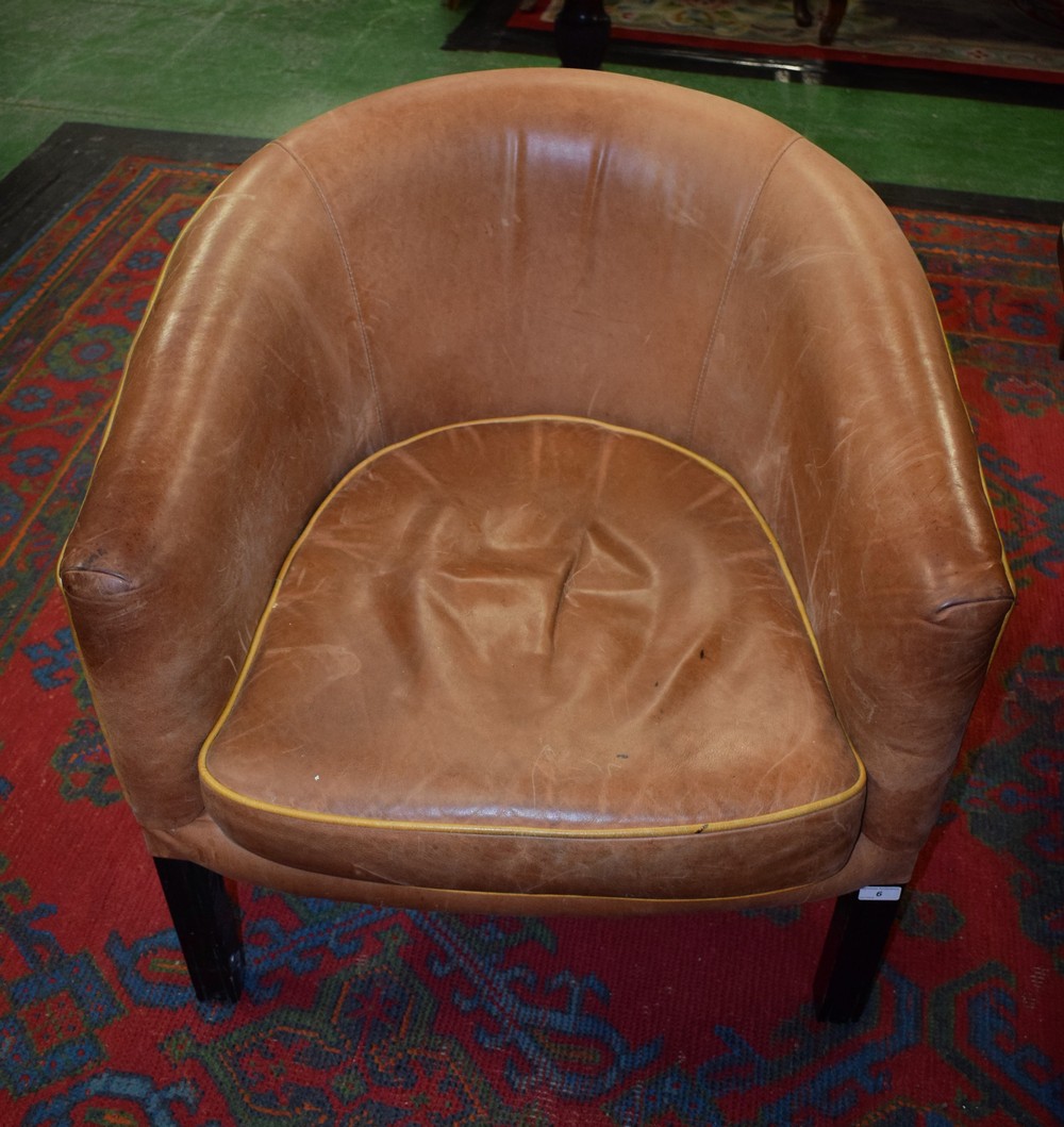 A 20th century club/tub chair, ebonised legs,