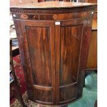 A George III mahogany bow-front corner cupboard,