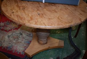 A Farmhouse pine kitchen table, near-circular top, bold vasular column, incurve triform base,