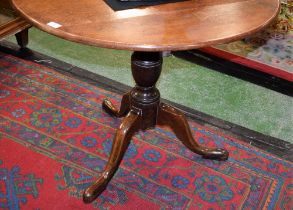 A George III oak tripod occasional table, circular tilting top, turned baluster column,