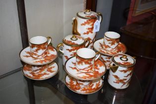 A Japanese Satsuma six-setting coffee set, painted with leafy trees in autumnal tones,