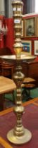 A tall floor standing brass alter type candlestick, dished drip tray,