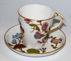 A Worcester cup and saucer, painted with flowers and butterflies picked out in gilt,