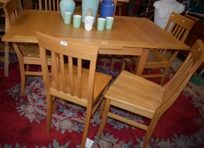 A contemporary light oak effect drawleaf dining table;