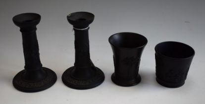 A pair of Wedgwood black basalt candlesticks, in relief with classical figures, leafy scrolls,