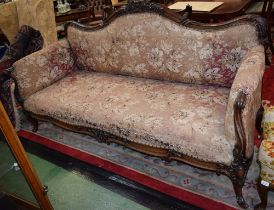 A Louis XV Revival rosewood sofa, shaped back crested by flowers and foliage, scroll hand rests,