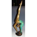 An Art Deco style bronze figure, as a ballet dancing girl with ball, green and gilt painted costume,