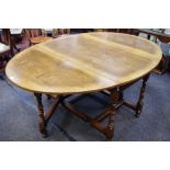 A Titchmarch & Goodwin oak oval drop leaf gateleg dining table, with a drawer either end,