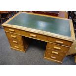 An oak pedestal desk, leather inlaid top one long drawer and two short to frieze,