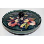 A Moorcroft pottery Orchid pattern tube lined powder bowl and cover, deep green blue ground,